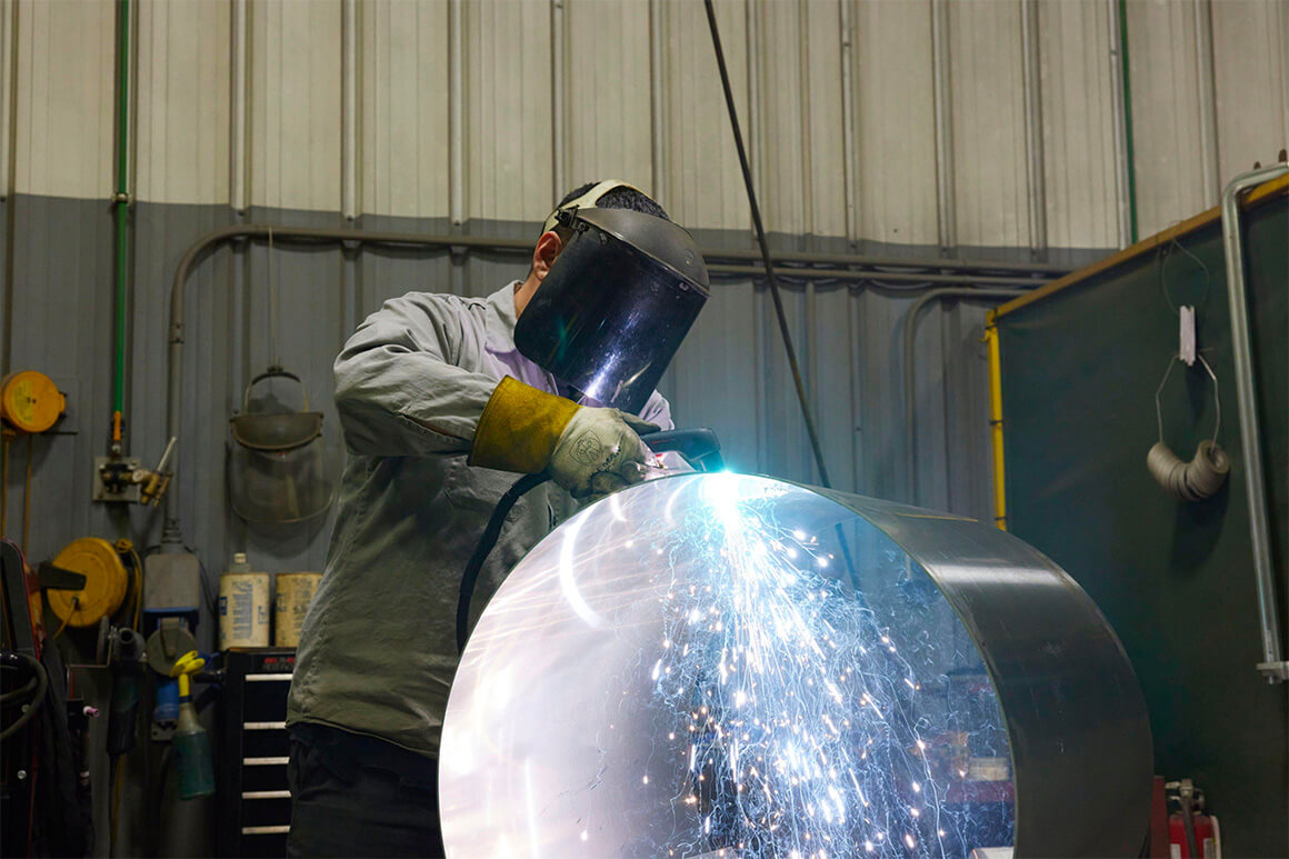 Worker welding a fuel tank